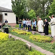 Pater Thomas und Pater Ulrich mit der Gruppe bei der Besichtigung des Kloster-Friedhofs